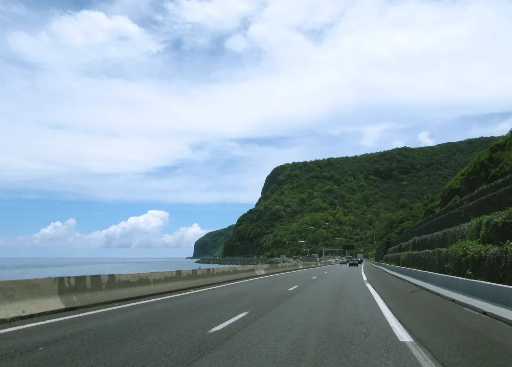 Route sinueuse du cirque de Salazie entourée de falaises verdoyantes et de végétation tropicale à La Réunion