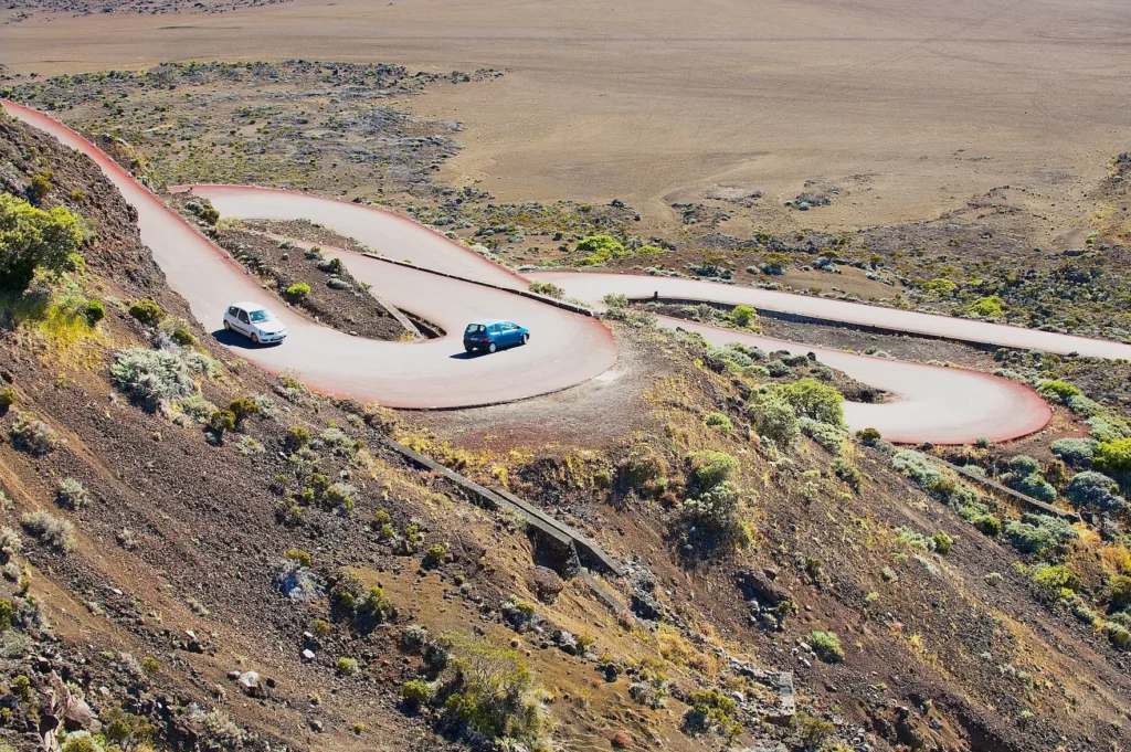 Deux voitures sur les lacets de la route du volcan menant au Piton de la Fournaise à La Réunion, paysage lunaire